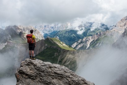 Photograph of one person standing on the mountaintop
